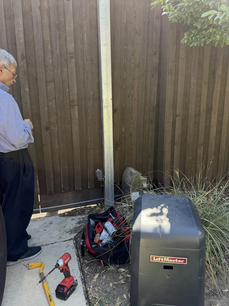 The completed repair photo shows the LiftMaster sliding gate after installation and adjustment of the new rust-free chain.
