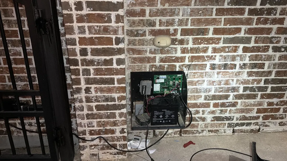 Battery, control board, and wiring inside the open enclosure.
