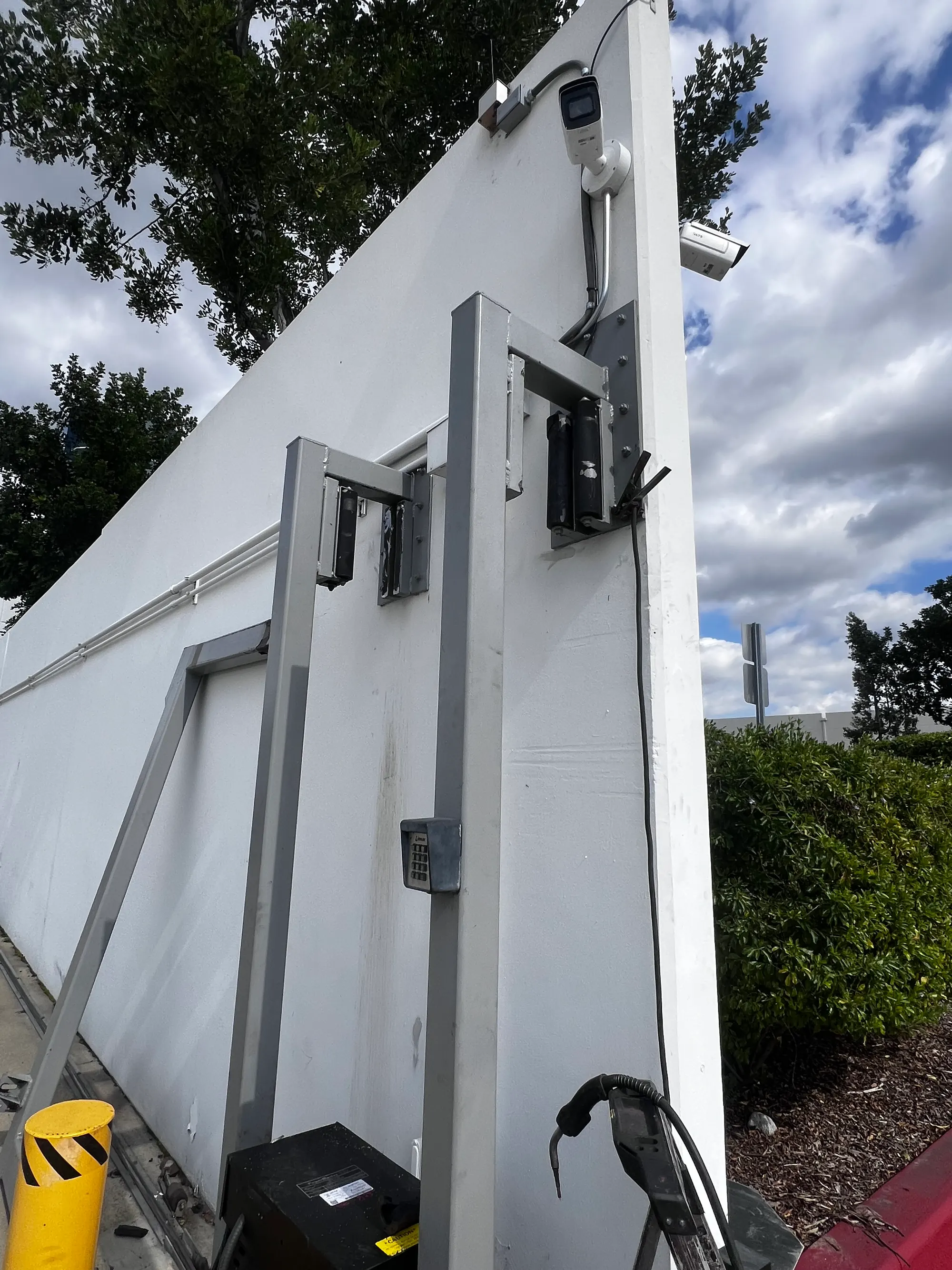A replacement heavy-duty steel post fixed to the wall at the end of the gate run