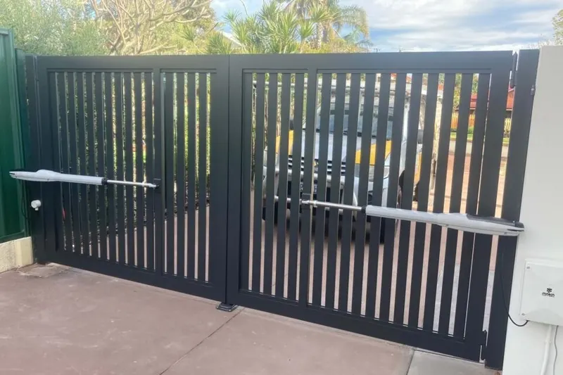 A newly installed automatic driveway gate closed across a residential entrance