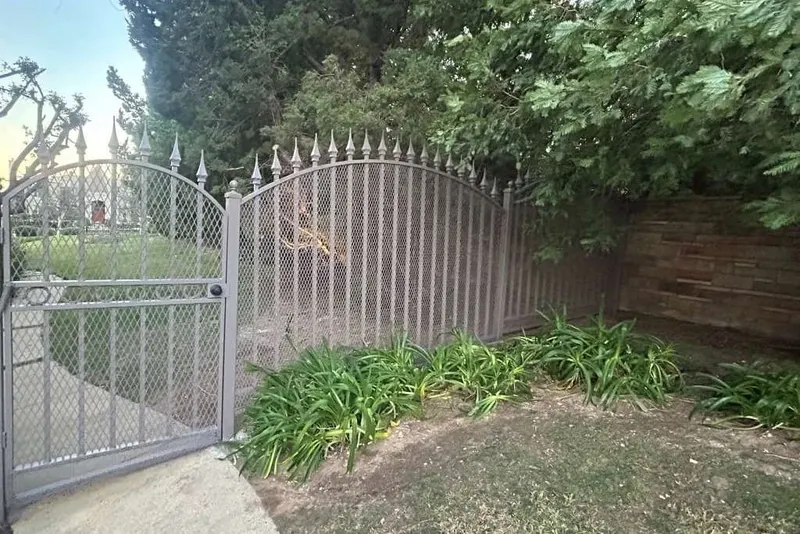 A new hinge welded into an iron gate post during repair