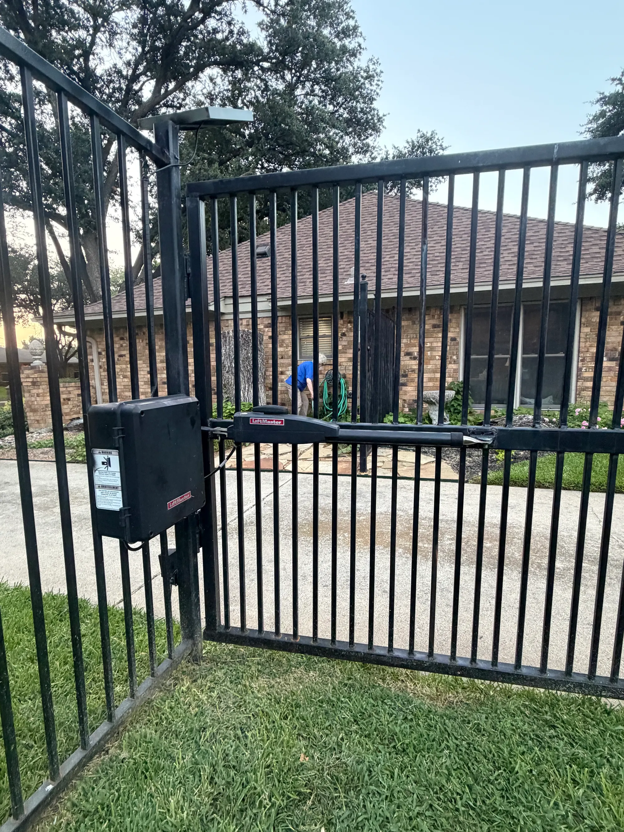 The LiftMaster operator arm and its closed control enclosure mounted on the iron gate after the replacement board was fitted