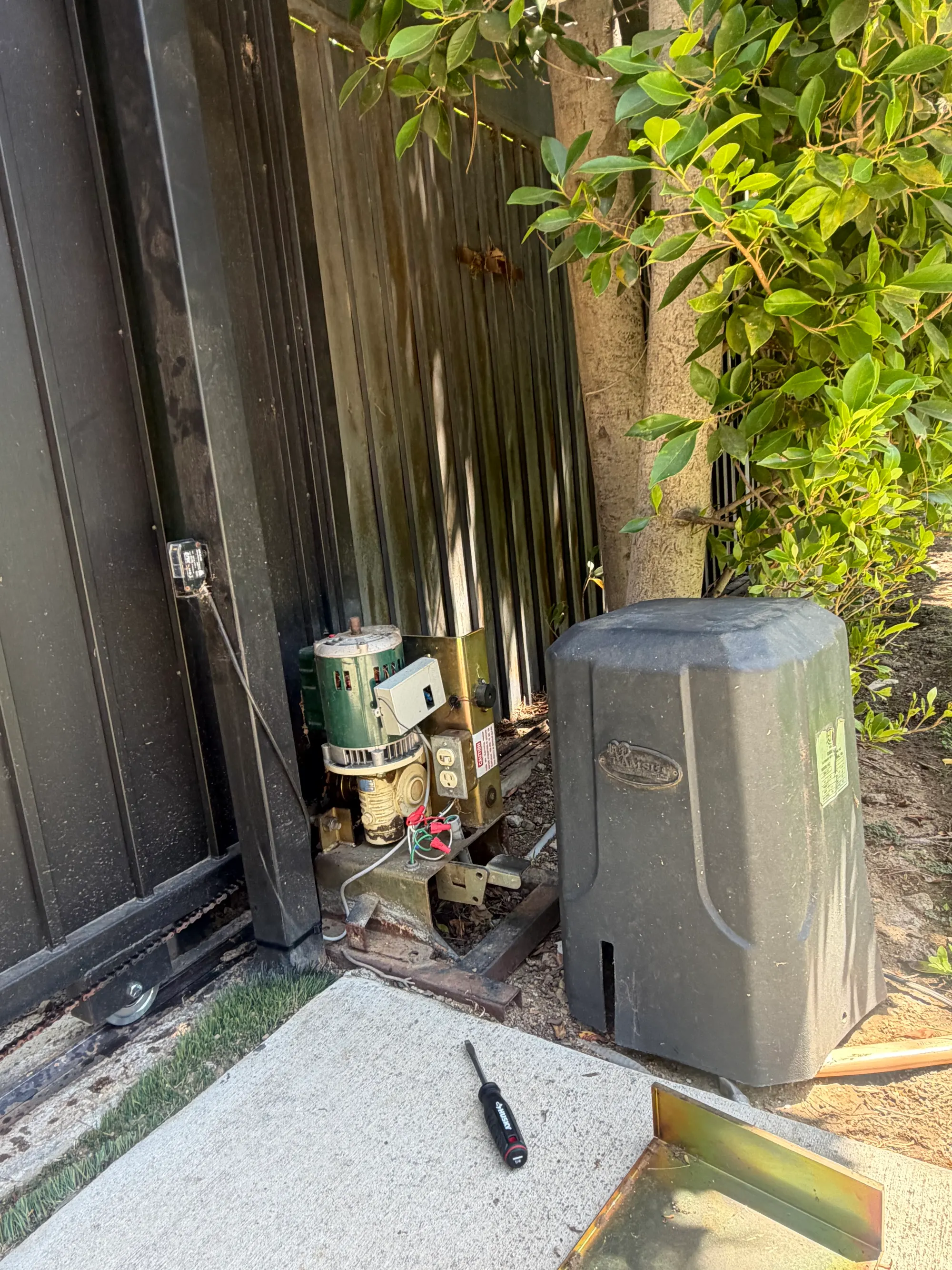 A Ramset slide gate operator and its control enclosure at the end of the gate run, beside the open gate
